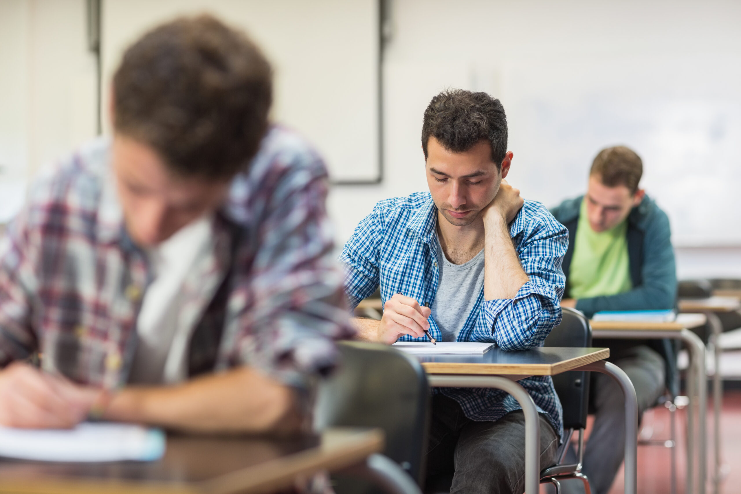 Group of young students writing notes in the classroom presentation-gand(oral-pulsess-sebastien-lacroix